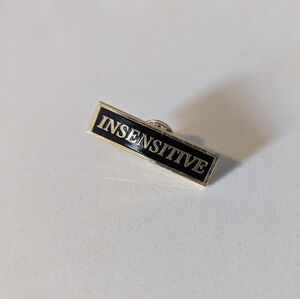 Insensitive Black and Gold Enamel Pin